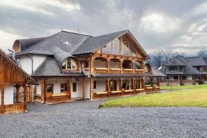 a large wooden house with a black roof at Prispa Premium Resort in Vişeu de Sus