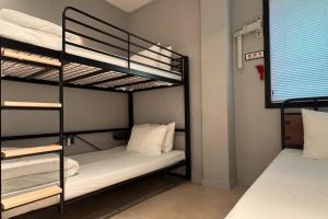 a bunk bed room with two bunk beds next to a window at Original Backpackers in Seoul