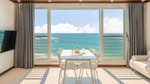 a dining room with a view of the ocean at GoSeong Beach Jin Spa Pension in Goseong