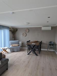 a living room with a table and a couch at Bright Holiday Home with Hot Tub Near Breda in Molenschot