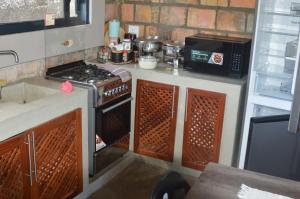 a small kitchen with a stove and a microwave at lodge3a in Ponta do Ouro
