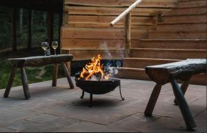 a fire pit with two benches on a patio at Journeyman in Bromyard