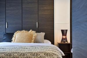 a bedroom with a bed with a wooden headboard at Sunstone GINOWAN 1F in Futemma +46 photos