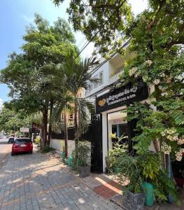 a building on the side of a street with trees at Siem Reap ABACUS Hotel in Siem Reap