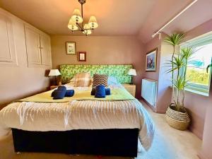 a bedroom with a large bed with blue pillows at Style 3BR House Jameston | Garden | Near Tenby in Tenby