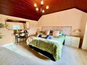 a bedroom with a bed and a mirror and a table at Style 3BR House Jameston | Garden | Near Tenby in Tenby