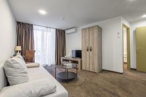 a living room with a couch and a tv at HOF Apartments in Kaunas