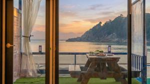 a table with a view of the ocean from a window at Goseong CNBLUE Oceanview Pension in Goseong