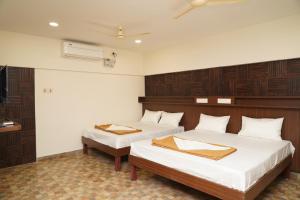 two beds in a room with wooden panels at DD COZY INN sntower in Tiruchirappalli
