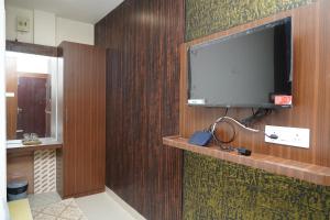 a bathroom with a tv on a wooden wall at DD COZY INN sntower in Tiruchirappalli