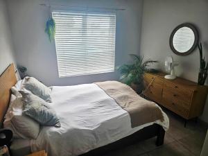 a bedroom with a bed and a mirror and a window at Quarter 5, Two Zero Four in Oakdale
