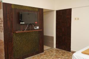 a room with a tv on a wall with a door at DD COZY INN sntower in Tiruchirappalli +32 photos
