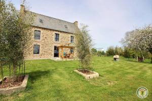 an old stone house with two trees in front of it at Ker illis in Lannion