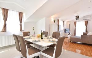 a dining room and living room with a table and chairs at Villa Cascata in Trilj