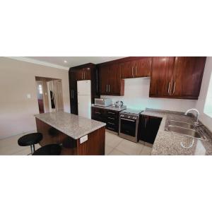 a kitchen with wooden cabinets and a counter top at Gorgeous Garden Villa 3 in Gillitts-Emberton