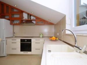 a kitchen with a sink and a stove and a window at Apartment Franka in Kaštela