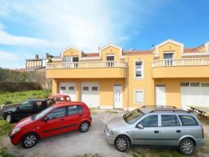 two cars parked in a parking lot in front of a house at Apartment Franka in Kaštela +3 photos