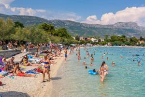 a group of people on a beach in the water at Apartment Franka in Kaštela