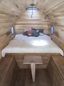 a large bed in a room with wooden walls at Citerne-Lit in Montredon