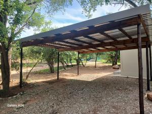 a wooden pergola in front of a building at Eagle's Retreat in Marloth Park