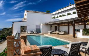 a villa with a swimming pool and a patio at Palacio de Cantalobos in Almuñécar