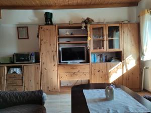 a living room with a tv on a wooden cabinet at Familienferienhof Sell´s Scheune in Sundhausen