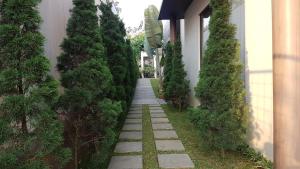 a garden with trees and a walkway next to a building at Vimalla Hills 2br Private pool, bebas Jam cekin, cekout sesuai jam cekin 24 jam,081tiga80satu6415satu in Gadok 1