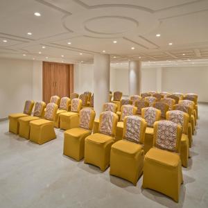 a conference room with yellow chairs and a podium at Regenta Z Vadodara in Vadodara