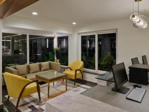 a living room with a couch and chairs and a television at Regenta Z Vadodara in Vadodara