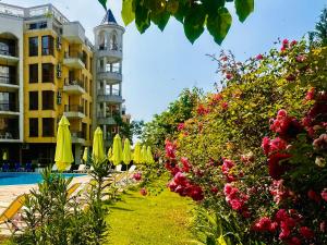 a resort with a swimming pool and a building and flowers at Diamond Palace in Sunny Beach