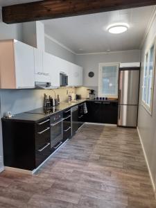 a kitchen with black cabinets and a refrigerator at Villa Sara in Kalajoki