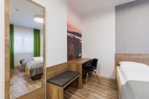a hotel room with two beds and a mirror at Das schlaf&GUT - Self Check-In in Leibnitz