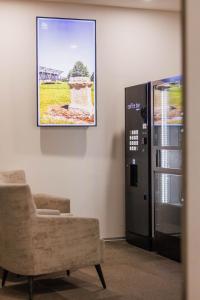 a living room with a chair and a picture on the wall at Das schlaf&GUT - Self Check-In in Leibnitz