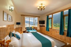 a bedroom with a large bed with blue curtains at Manali Golden Valley in Manāli