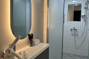 a bathroom with a sink and a shower with a mirror at Original Backpackers in Seoul