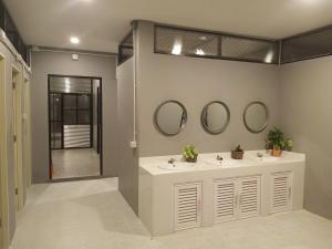 a bathroom with two sinks and mirrors on the wall at Thesleeperhomestay in Ban Chuk Kum