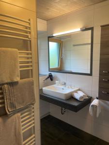 a bathroom with a sink and a mirror and towels at Ferienhaus Julia in Admont +21 photos