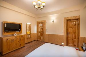 a large room with a television and a bed at Manali Golden Valley in Manāli