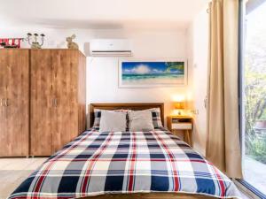 a bedroom with a bed with a plaid blanket at Cute apartment hagoshrim in HaGoshrim