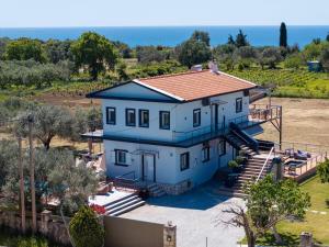 a large blue house with a red roof at Villa Sorina Kefalonia in Svoronata