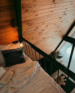 a bed in a room with a wooden wall at The Palo Cabins in Predeal