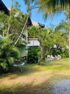 a resort with chairs and palm trees in front of it at Maresias Praia Hotel in Maresias