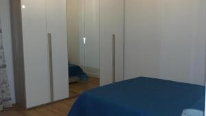 a bedroom with white cabinets and a mirror at Affitti brevi Liguria - La Conchiglia in Savona +5 photos