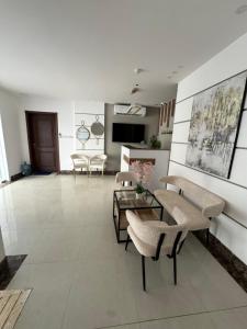 a large living room with chairs and a table at Taqah Beach Front Apartment in Ţāqah