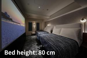 two beds in a hotel room with a tv at The Lively Osaka Honmachi in Osaka +40 photos