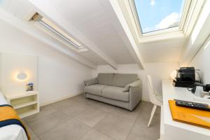 a room with a chair and a desk and a window at Zia Pupetta Suites in Amalfi
