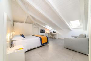 a white bedroom with a bed and a couch at Zia Pupetta Suites in Amalfi