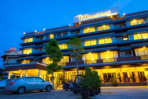 a hotel with cars parked in front of it at TH beach hotel in Hua Hin