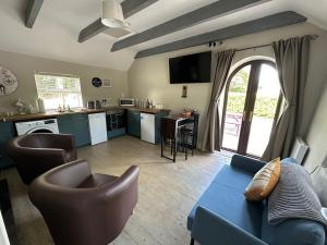 a living room with a blue couch and a kitchen at Riverside Cottage in Kildare