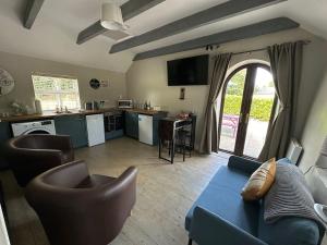 a living room with a blue couch and a kitchen at Riverside Cottage in Kildare +47 photos